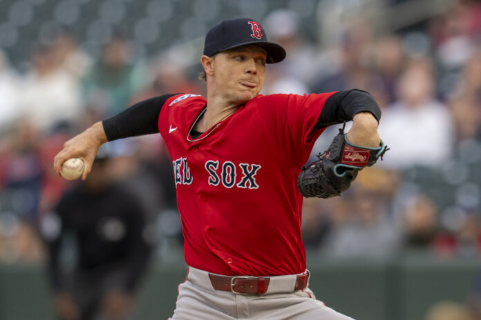 MLB Boston Red Sox at Minnesota Twins Baseball pitcher in a red Boston Red Sox uniform throwing a pitch on the mound, glove on his left hand.