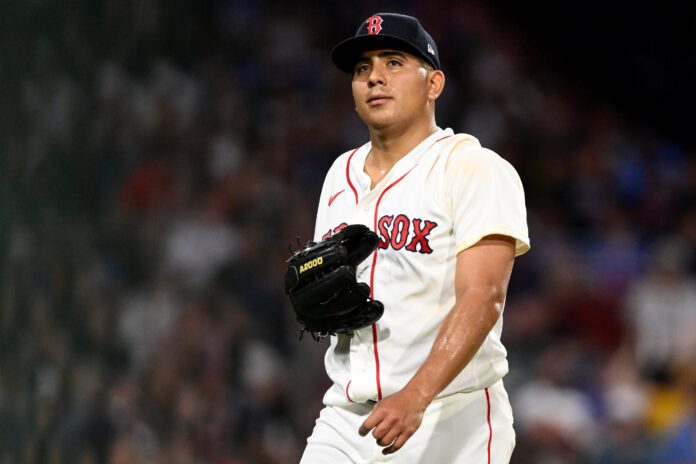 MLB Washington Nationals at Boston Red Sox Baseball player in a Red Sox white uniform with a black glove on the field, looking ahead during a game.
