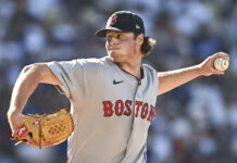 Red Sox Hot Streak Ends as Gage Jump Dominates Again Baseball pitcher in a Boston Red Sox uniform mid-pitch, throwing a ball with his right arm extended and glove on left hand.